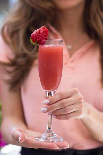 Cocktail rossini e mano delle donne concetto di bevanda deliziosa cocktail rossini su sfondo naturale