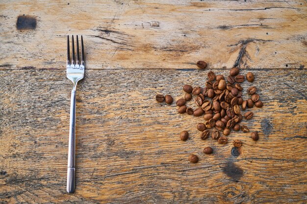 Rosted coffee beans and fork on a table