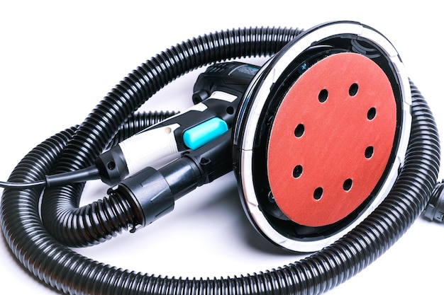 Rotary grinder with a black corrugated hose to connect to a vacuum cleaner isolate on a white background