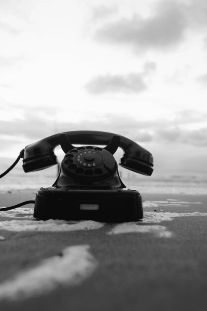 Foto telefono rotativo sulla spiaggia contro il cielo