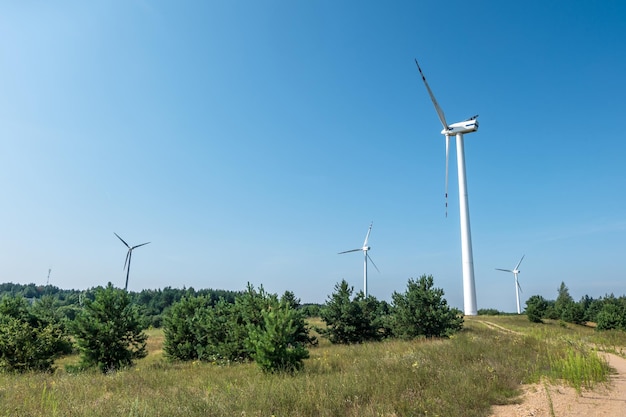 Rotating blades of a windmill propeller on blue sky background Wind power generation Pure green energy