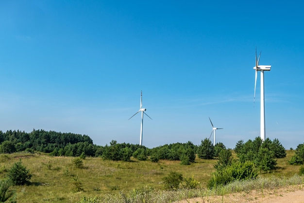 Rotating blades of a windmill propeller on blue sky background Wind power generation Pure green energy