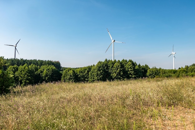 Roterende bladen van een windmolenpropeller op blauwe hemelachtergrond Windenergieopwekking Zuivere groene energie