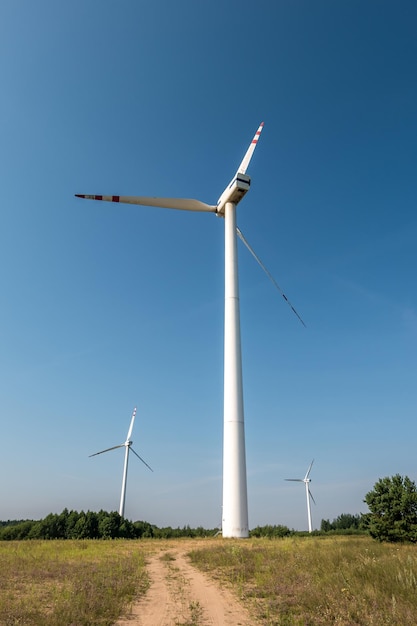 Roterende bladen van een windmolenpropeller op blauwe hemelachtergrond Windenergieopwekking Zuivere groene energie