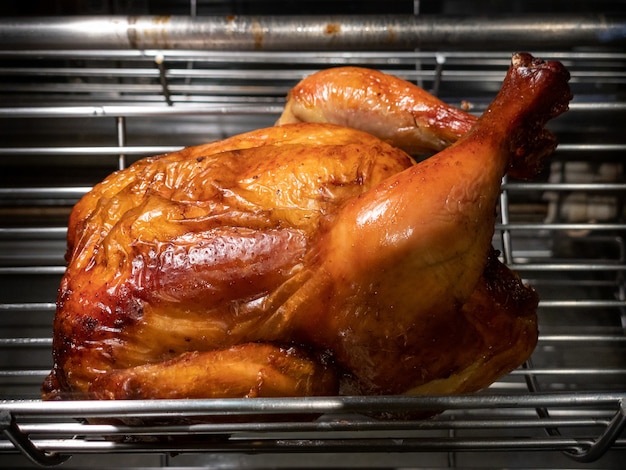 Roterende machine zijn gegrilde hele kip. Geroosterde kippen in een rij die bij industriële brander draaien. Een barbecue gebraden spies in een commerciële oven rotisserie.