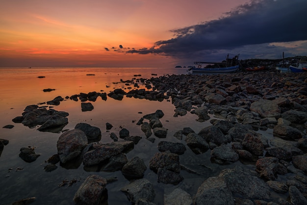 Foto rots op het strand met zonsonderganghemel