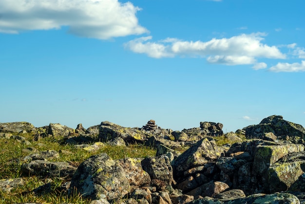 Rotsachtig grasachtig terrein op een bergpas en een blauwe lucht met wolken erboven