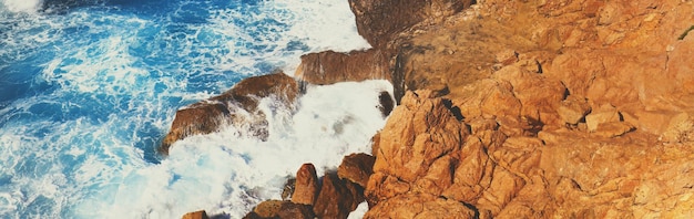 Foto rotsachtige kust stormachtige zee prachtige wilde natuur horizontale vlag