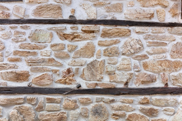 Rotsachtige muur met donkergrijze cement parallelle lijnen achtergrondstructuur Oude beige stenen muur Kopieer ruimte