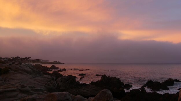 Rotsachtige oceaan zee strand californië kust roze paars pastel dramatische zonsondergang hemel