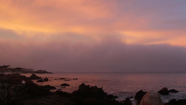 Rotsachtige oceaan zee strand californië kust roze paars pastel dramatische zonsondergang hemel