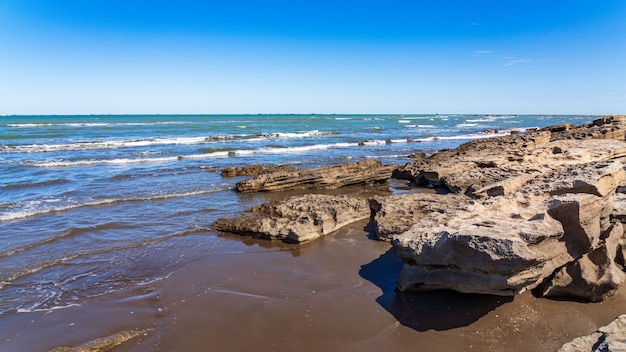 Rotsachtige zeekust met blauw water en kleine golven