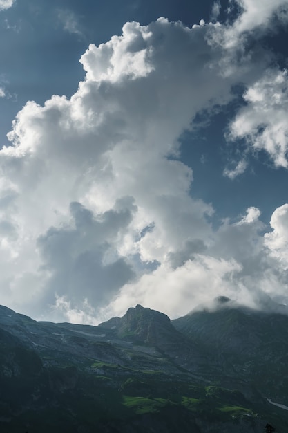 Rotsen en een pas met een blauwe lucht met zonnestralen die door de wolken breken. Fisht Oshten is een bergtop in het westelijke deel van de Kaukasische Main Ridge