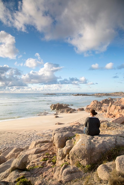 Rotsen en vrouw op Forcados Point Beach, Costa de la Muerte, Galicië, Spanje