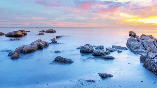 Foto rotsen in de zee tegen de lucht bij zonsondergang