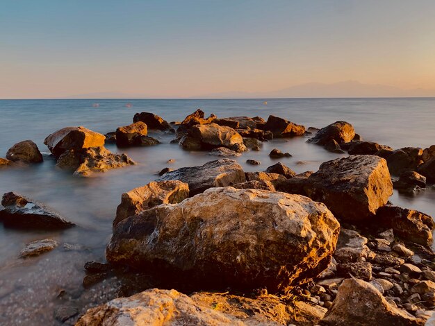 Rotsen op de kust tegen de hemel bij zonsondergang