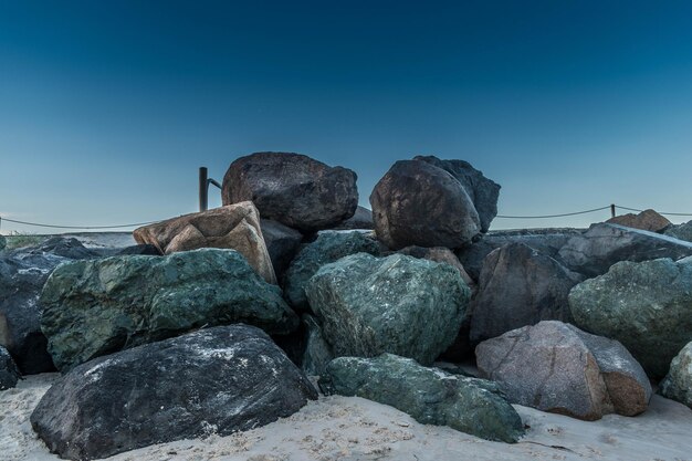 Rotsen op het strand tegen een heldere blauwe hemel