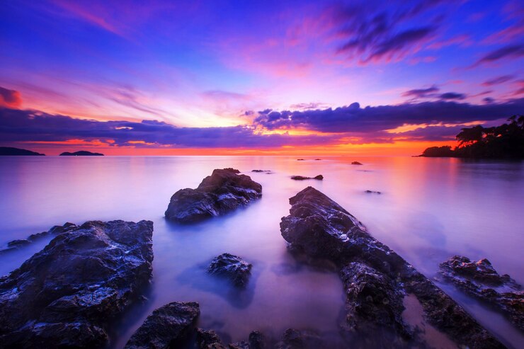 Rotsen op het strand, Zeegezicht in zonsonderganghemel en overzees bij het strand van de Tarn Khu - Trat, Thailand.