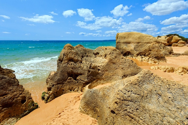 Rotsen op het zomerzandstrand van Albufeira (Algarve, Portugal).