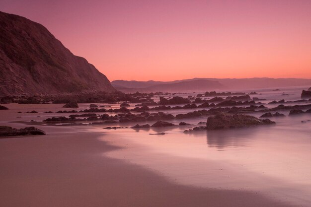 rotsformaties op het strand bij zonsonderganglicht