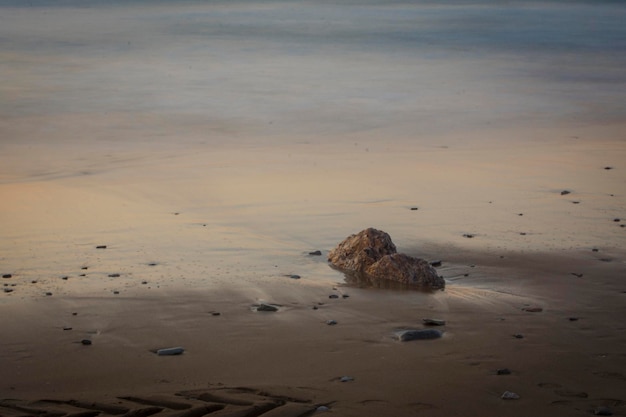 rotsformaties op het strand onder het zonsonderganglicht