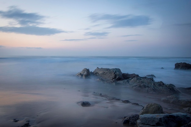 rotsformaties op het strand onder het zonsonderganglicht