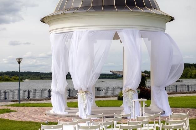 Rotunda, column, Palace style. Arch for weddings and exit ceremonies decorated with white tulle. design and architecture, weddings. Wedding decor