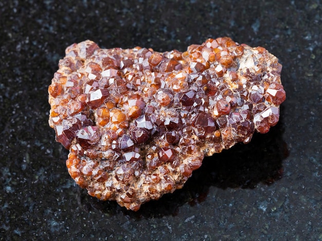 Rough Andradite garnet crystals on stone on dark