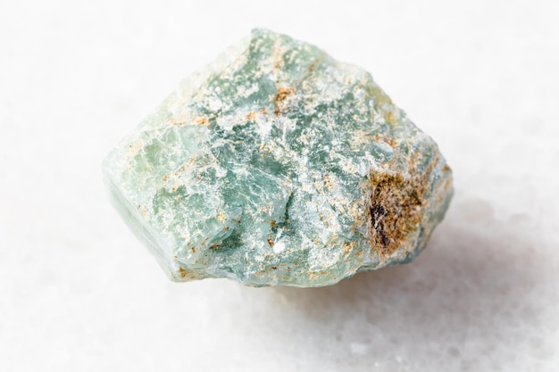 Rough Apatite rock on white marble