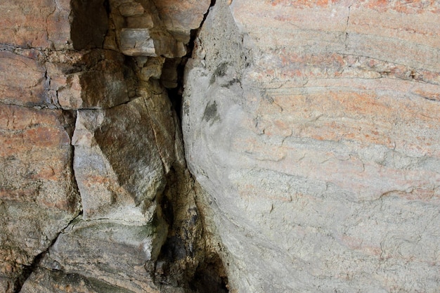 荒い茶色の石の壁古い石の岩の風化した表面のテクスチャクローズアップ