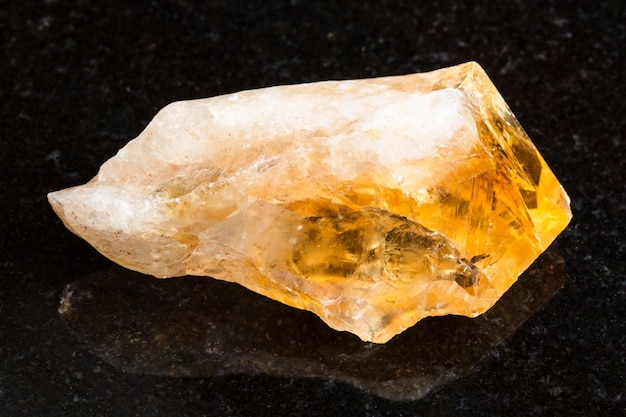 Rough crystal of Citrine gemstone on black