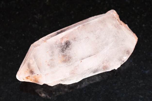 Rough crystal of rose quartz gemstone on dark