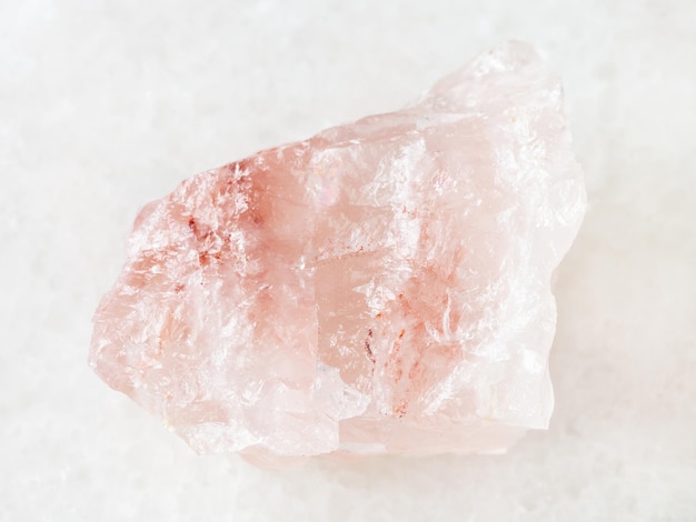 Rough crystal of rose quartz gemstone on white