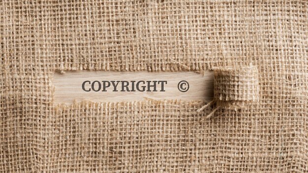 Грубая льняная ткань с рваным участком, на котором написано слово Copyright