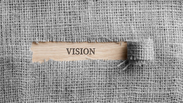 Rough linen fabric with a torn window in the middle with a Vision sign in it