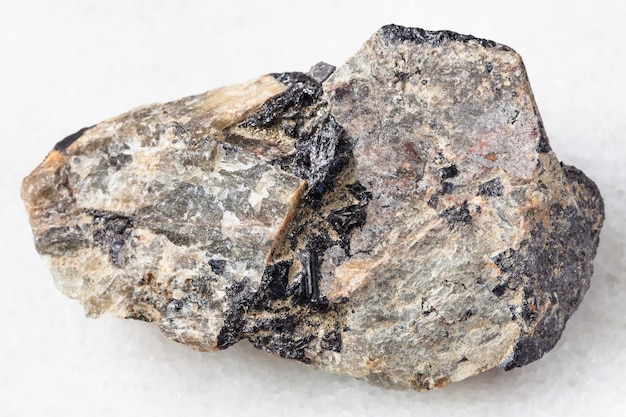 Rough Nepheline stone with Ilmenite vein on white