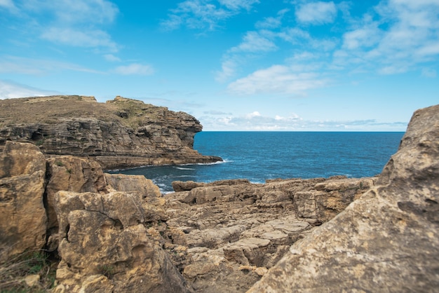 Rough rocky cliff in spectacular seascape on cloudy day