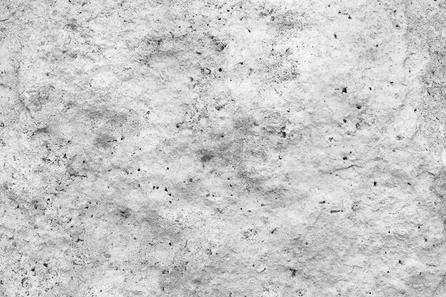 Rough, uneven texture of a gray concrete wall closeup.