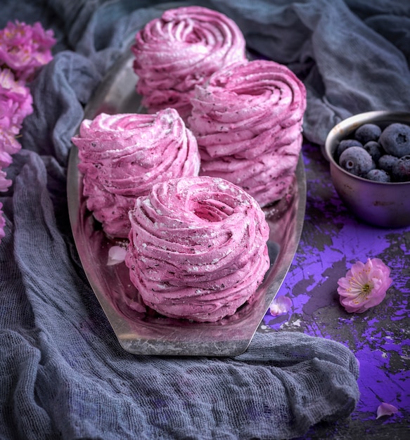 Round airy marshmallow with blueberries onn iron plate