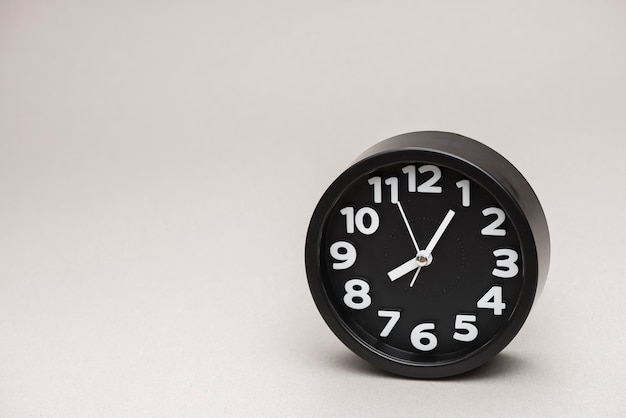 Photo round black alarm clock against gray background