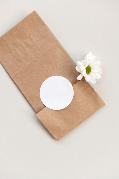Foto modello di adesivo rotondo vuoto modello di etichetta rotonda su fiore margherita borsa regalo in carta kraft