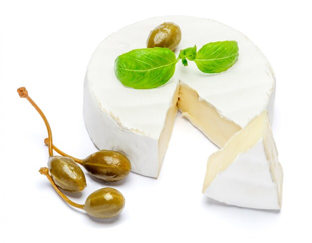 Round brie or camembert cheese on a white table