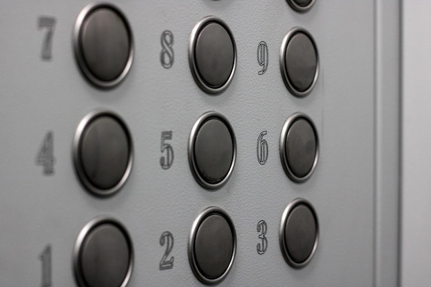 Photo round buttons on the gray wall of the elevator