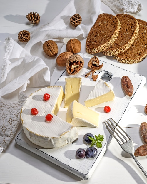 Formaggio rotondo camembert sul bordo di legno bianco