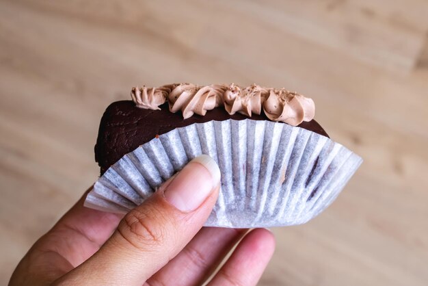 Foto torta al cioccolato rotonda in mano da vicino