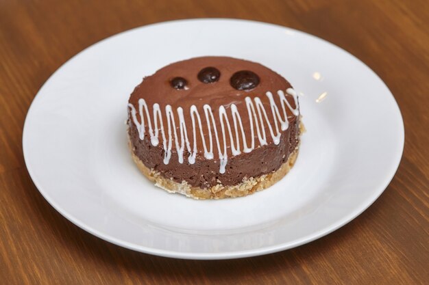 Round chocolate cake on plate, close up