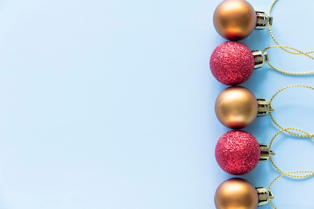 Round Christmas toys are assembled in a row and lie on a blue background with a place to copy