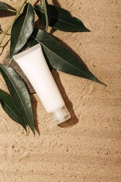 round container for cosmetic products on a background of sand