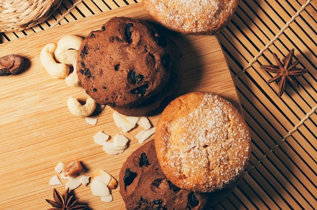 Round crispy chocolate cookies with spices and nuts on cutting board