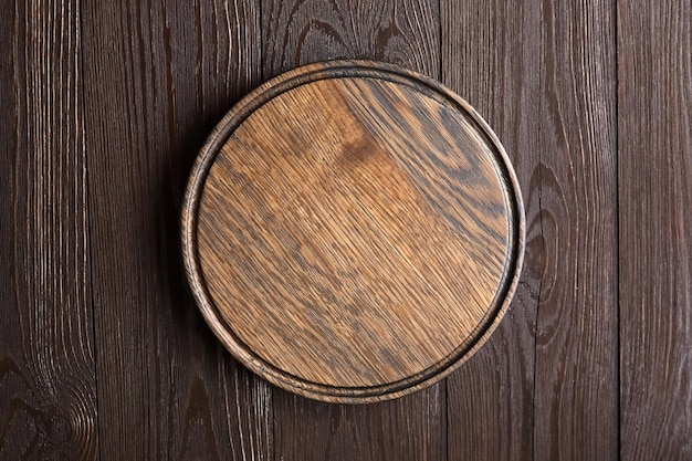 Round cutting board with groove on wooden table